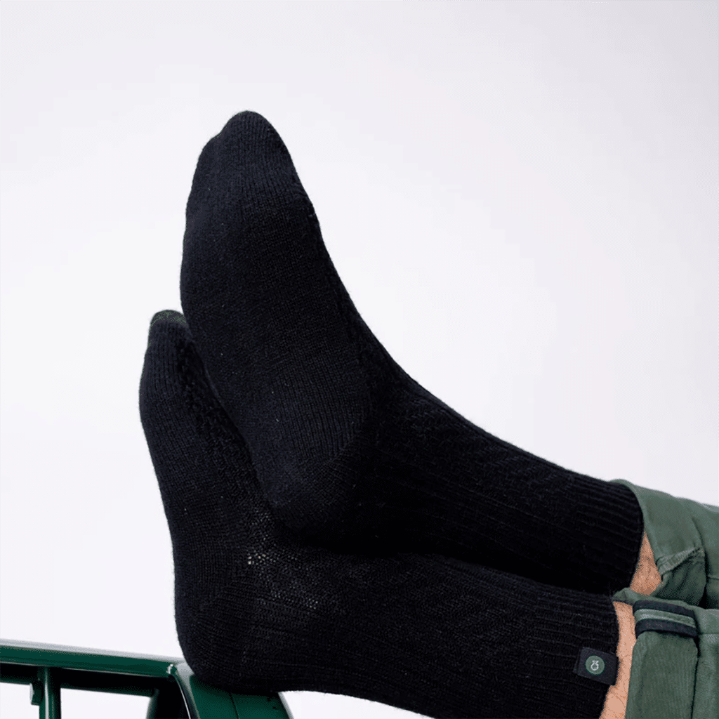 une paire de chaussettes en laine noir Billyblet, vue de côté sur fond blanc
