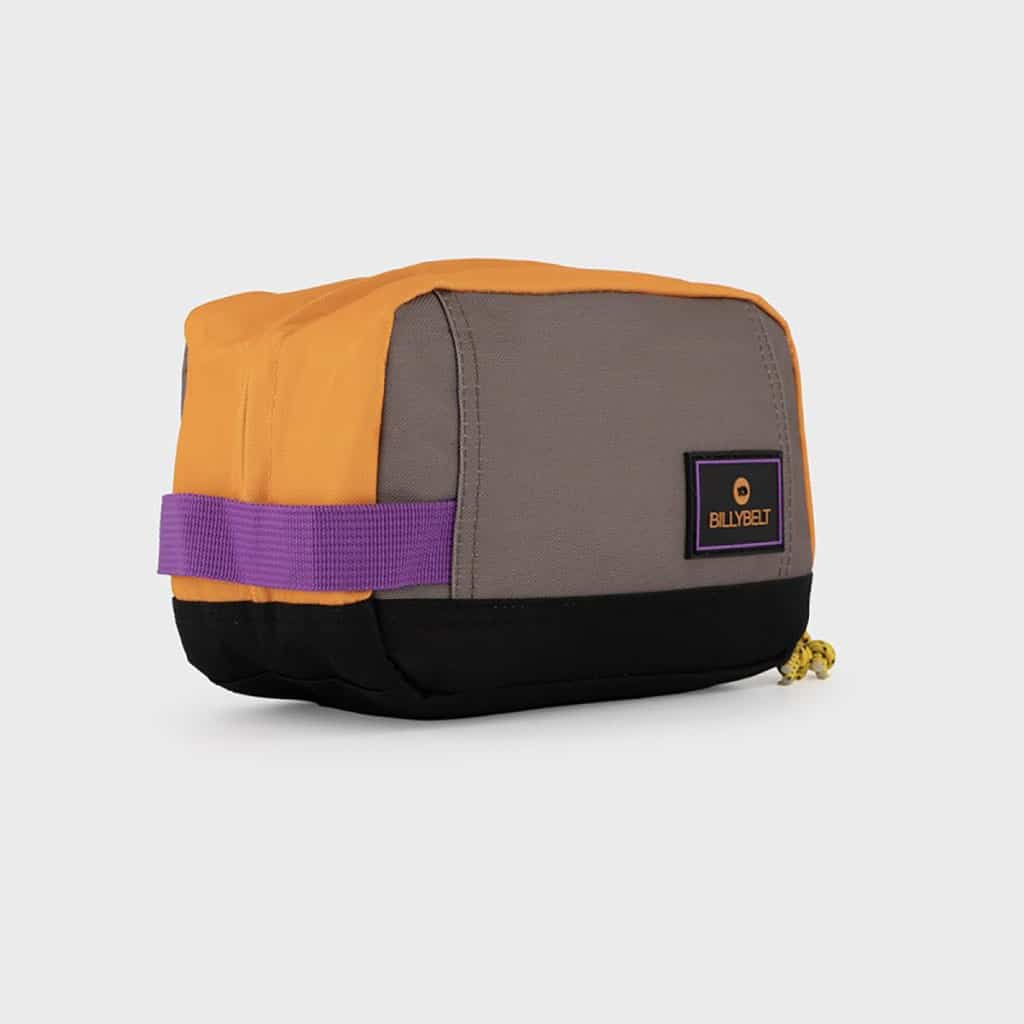 Une trousse de toilette en polyester recyclé orange et taupe Billybelt, vue de côté sur fond blanc