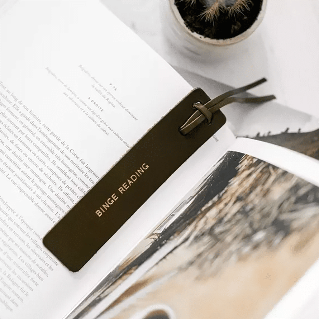 un marque page en cuir "Binge Reading", vue de face sur fond blanc