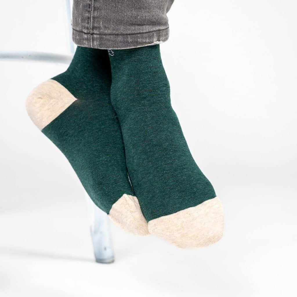 Une paire de chaussettes en coton peigne unies vert foncé chiné, ambiance porté
