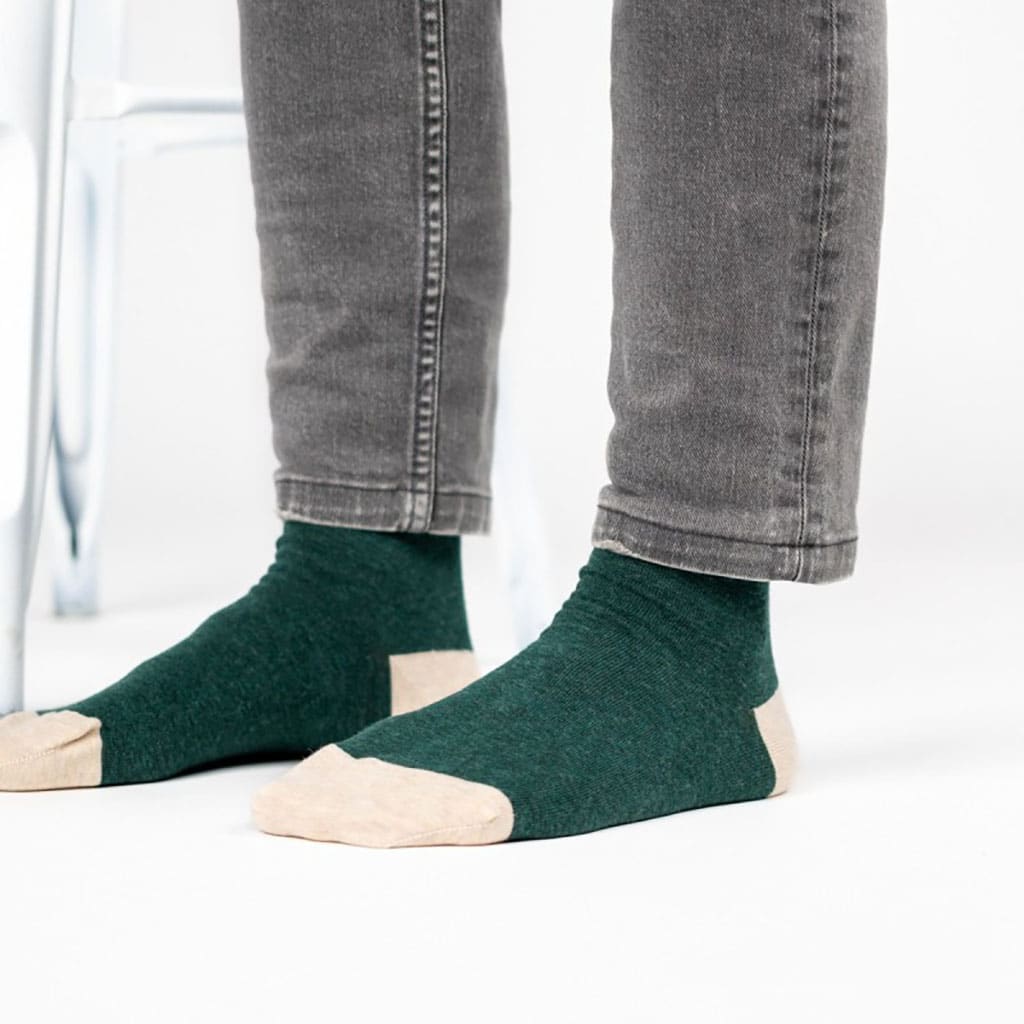 Une paire de chaussettes en coton peigne unies vert foncé chiné, ambiance porté