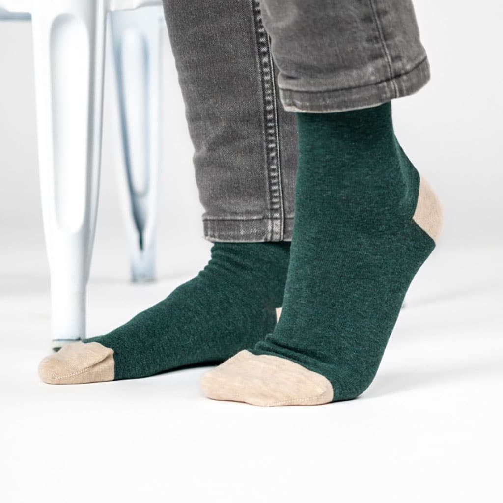 Une paire de chaussettes en coton peigne unies vert foncé chiné, ambiance porté